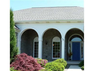 Exterior Front. The triple arched entry, lush land