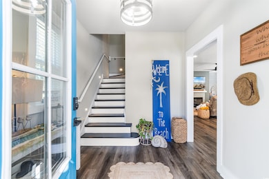 Foyer entrance with ceiling fan and dark wood-type flooring