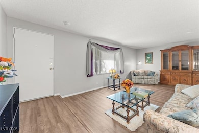 Living area featuring a textured ceiling and light wood finished floors