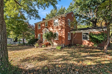 This almost half acre lot features beautiful mature trees.  The added family room is seen on the left.