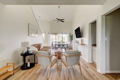 Living area featuring ceiling fan, light wood fini