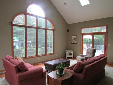 The spacious Morning Room/Sunroom has a Vaulted Ceiling & carpet surrounded by hardwood flooring. The slider leads out to the deck.