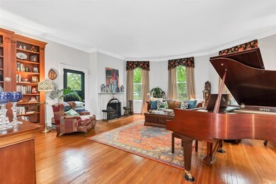 The large, light-filled living room is in the addition from the late 1800s and includes a front bay window. A marble mantle and new granite hearth surround a wood burning fireplace. The owners had it re-lined and outfitted with a high-end, high-effic