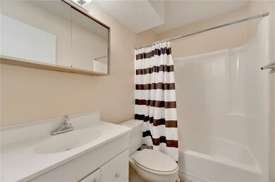 Bathroom featuring vanity, a textured ceiling, and shower / bath combo with shower curtain