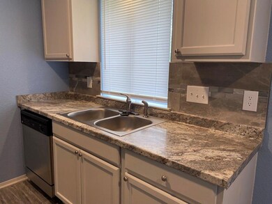 Kitchen featuring a sink, dishwashing machine, st