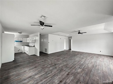 Unfurnished living room with a ceiling fan and dark wood-style floors