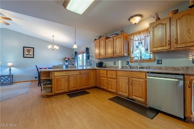 Kitchen, stainless steel dishwasher, light wood finished floors, plenty of natural light, and a peninsula