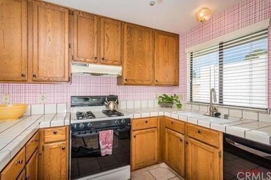 Bright kitchen with tiled counters and window over