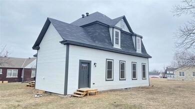 Rear view of property featuring entry steps, roof 