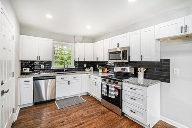 A separate Dining Room sits just off the entry and flows seamlessly into the New Kitchen featuring White Shaker Cabinets, Black Subway Tile Backsplash, Granite Countertops, and Stainless Steel Appliances the perfect space for everyday cooking or ente