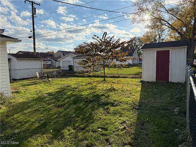 Fenced backyard featuring a storage shed