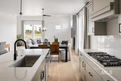 Kitchen featuring appliances with stainless steel finishes, light wood-type flooring, tasteful backsplash, hanging light fixtures, and ceiling fan