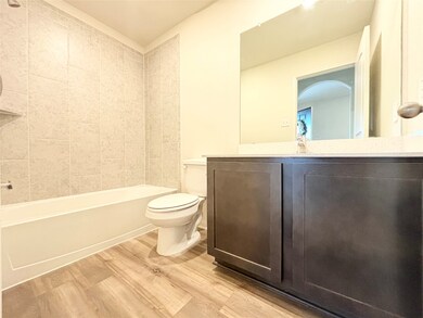 Bathroom with vanity, bathing tub / shower combination, and light wood-style floors