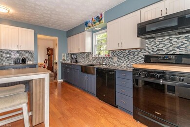 Kitchen with white cabinets, backsplash, light har