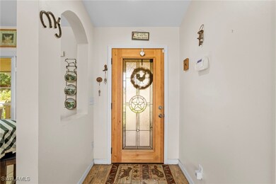 Doorway to outside featuring baseboards, arched wa