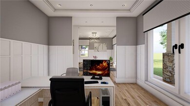 Home office featuring light wood-type flooring, a raised ceiling, a decorative wall, healthy amount of natural light, and wainscoting