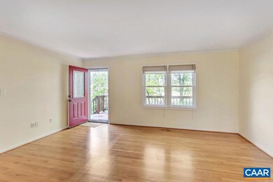 Bright & sunny living room featuring hardwood flooring and open to the eat-in area of the kitchen.