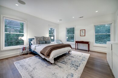 Enjoy serene treetop views in the peaceful owner's suite featuring a king-size layout, Hunter Douglas remote-control blinds and a wall-mounted TV.