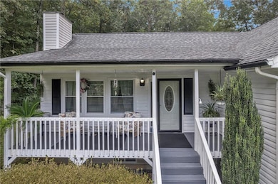 Entrance to property with a porch, a shingled roof, and a chimney