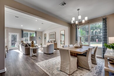 Dining area featuring lofted ceiling with beams, wood-type flooring, and a chandelier