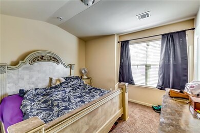 Carpeted bedroom featuring visible vents, baseboar