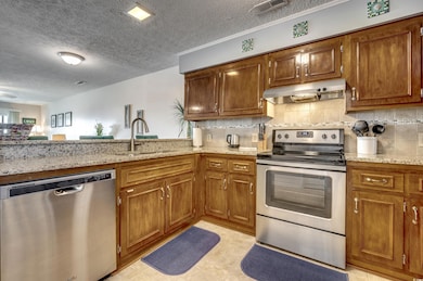 Kitchen featuring light stone counters, a textured