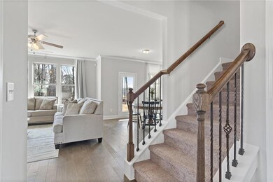 Staircase featuring a ceiling fan, crown molding, 