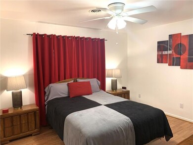 Bedroom with laminate floors and ceiling fan.