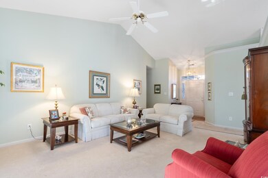 Carpeted living room featuring high vaulted ceilin