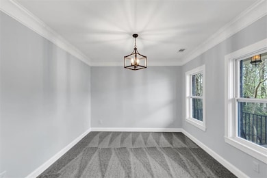 Carpeted spare room with an inviting chandelier, v