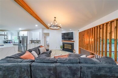 Living room with a chandelier, recessed lighting, and a large fireplace