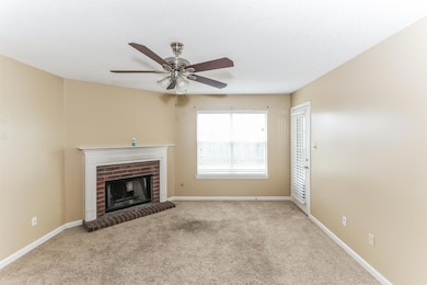 Unfurnished living room with carpet, a brick fireplace, ceiling fan, and a textured ceiling