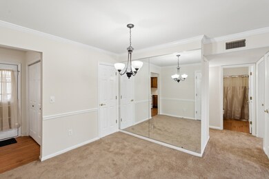 Dining room close up with wall of mirrors. Hall to bedrooms showing hall bath. Hall bath has a private  entrance  from second bedroom. On the left, door to patio and doors to utility closet.