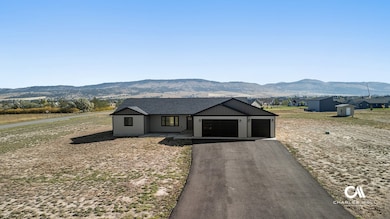 Modern inspired farmhouse with a mountain view, driveway, board and batten siding, a garage, and roof with shingles