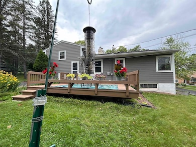 Back of house with a chimney, a wooden deck, and a yard