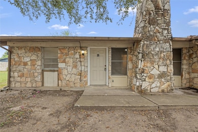 Entrance to property featuring stone siding