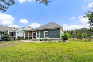 Rear view of house featuring a sunroom and a patio