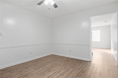 Spare room featuring crown molding, wood finished floors, and ceiling fan
