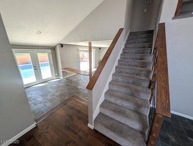 Stairway with french doors, stone tile floors, bas