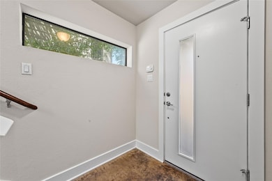 Entryway featuring baseboards and concrete flooring