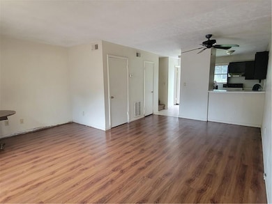 Unfurnished living room with wood finished floors, a ceiling fan, and baseboards
