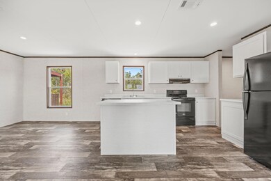 Kitchen with black appliances, white cabinets, ple