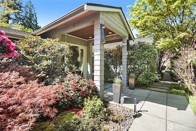 A vibrant tapestry of mature landscaping envelops the private entrance, setting a tone of natural elegance and seclusion from the moment you arrive.