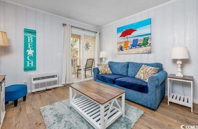 Living area featuring wood finished floors, a wall unit AC, and wooden walls