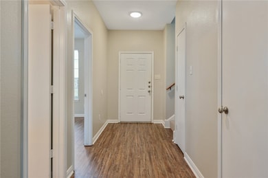 Hallway featuring dark wood finished floors and baseboards