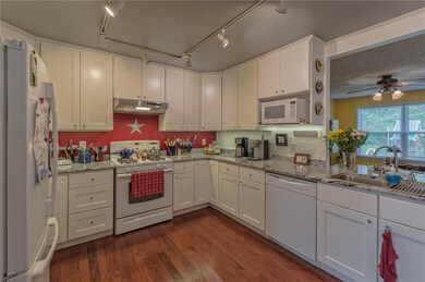 Spacious kitchen has hardwood floors and is open t