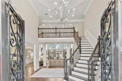 Foyer with crown molding, visible vents, stairway,