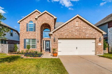 A grand two-story entry features a bricked archway beneath the gable forming the covered porch.