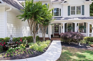 View of exterior entry with a porch and roof with shingles