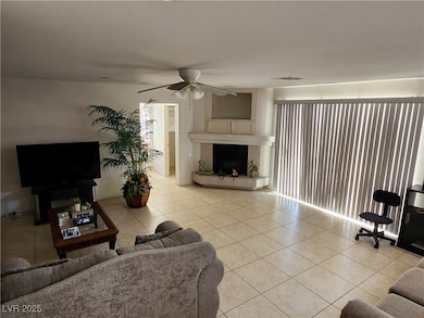 Living area featuring a ceiling fan, light tile pa